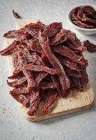 AI generated Gourmet Dried Beef on Wooden Board photo