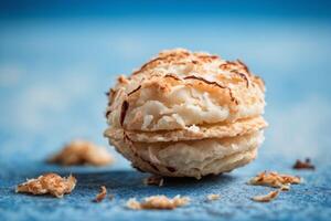 AI generated Golden Coconut Macaroon on Blue Surface photo