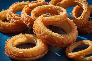 AI generated Golden Fried Onion Rings on Blue Background photo