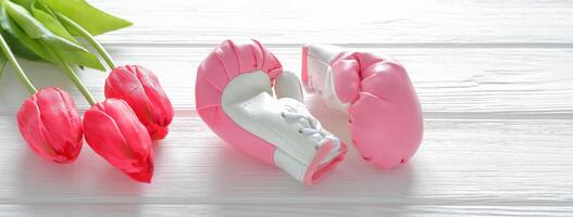 Tulips flowers and boxing gloves on wooden background, femenism concept photo