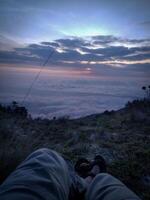 silueta de un montaña trepador en contra un hermosa puesta de sol antecedentes foto