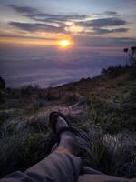 silueta de un montaña trepador en contra un hermosa puesta de sol antecedentes foto