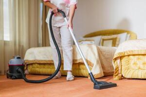 Close up image of hotel maid vacuuming room. photo