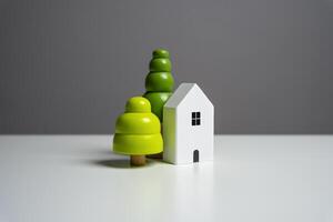 House and decorative trees, figurines. Buying and selling real estate. Housing prices. photo
