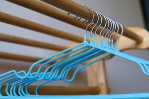 Empty clothes hangers on wooden rack photo