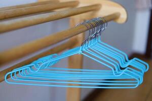 Empty clothes hangers on wooden rack photo