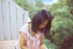 Young asian woman in casual clothes standing alone and looking down on the balcony photo