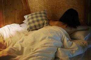 Rear view of a naked woman lying down on the bed photo