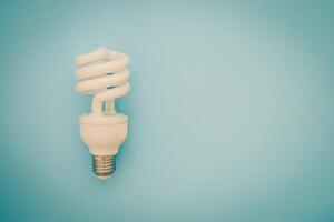 Fluorescent light bulb on blue background photo