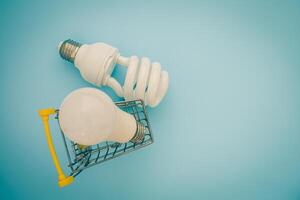 Fluorescent and LED light bulb with mini shopping cart photo