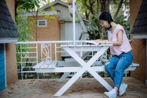 Young asian girl reading a book at the terraces photo