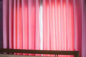 rosado cortinas con luz de sol mediante el ventana foto