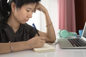 Woman using laptop and working at home photo