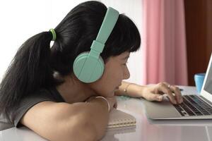 Woman wearing headphones, using laptop and staying at home photo