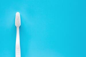 blanco cepillo de dientes usado para limpieza el dientes en azul antecedentes foto