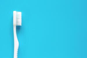 blanco cepillo de dientes usado para limpieza el dientes en azul antecedentes foto