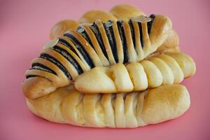 Delicious bread on pink background photo