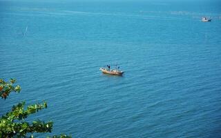 ver de mar superficie y pescador barco foto