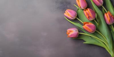 AI generated Colorful tulip flowers on dark concrete background, spring flat lay banner. Valentine's, womens, mothers day, birthday or wedding concept. Top view. Copy space. Generated AI. photo