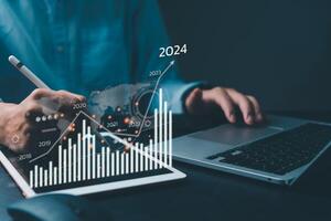 financiero cartas y grafico análisis márketing demostración creciente ingresos en 2024 flotante encima digital pantalla tableta, negocio acerca de estrategia para crecimiento y éxito. foto