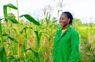 cerca arriba de un hermosa africano dama en pie en el granja foto