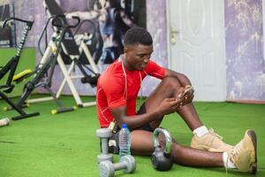 online trainer in the gym using his cellphone to check thing online photo