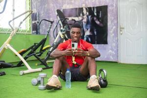 guy operating his phone feeling excited in the gym photo