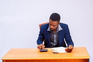 young handsome african businessman isolated over white background calculating his invoice photo