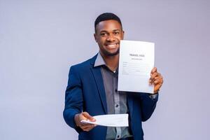 handsome young travel agent smiling as he holds visa application form photo