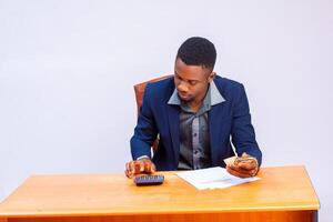 handsome african business using calculator to calculate his expense photo