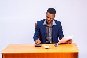 africano empresario sonriente como él analizar el presupuesto en su mano foto