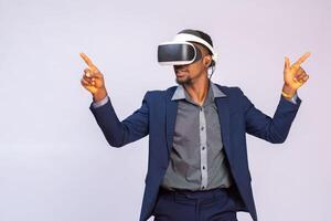 cerca arriba retrato de hermoso hombre jugando vídeo juegos en gafas de protección o 3d lentes. africano jugador vistiendo virtual realidad auriculares para inteligente teléfono en su cabeza, sonriente, en pie en contra blanco antecedentes foto