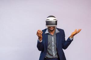 Handsome man playing video games in VR goggles or 3d glasses, wearing virtual reality headset for on his head photo