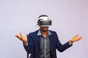 cerca arriba retrato de hermoso hombre jugando vídeo juegos en gafas de protección o 3d lentes. africano jugador vistiendo virtual realidad auriculares para inteligente teléfono en su cabeza, sonriente, en pie en contra blanco antecedentes foto