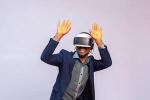 Amazed young man playing video games in VR goggles or 3d glasses, wearing virtual reality headset for on his head photo