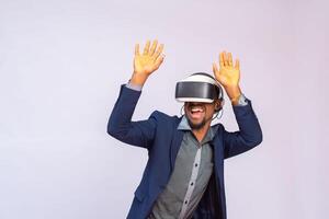 Amazed young man playing video games in VR goggles or 3d glasses, wearing virtual reality headset for on his head photo