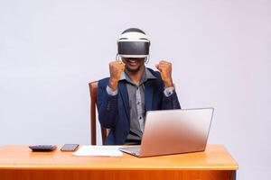 African American man using virtual reality in office feeling excited photo