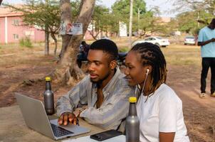Cheerful man and woman watching video on laptop smiling and laughingCheerful man and woman watching video on laptop smiling and laughing photo
