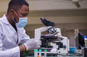 biochemical research scientist working with microscope for coronavirus vaccine development photo