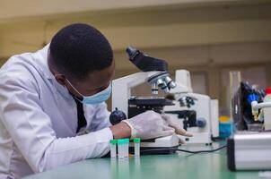 handsome Scientist or medical in lab coat working in biotechnological laboratory, photo