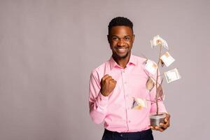 man feeling excited as he holds money tree photo