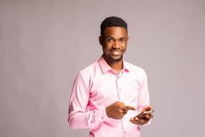 handsome african man in isolated over white background smiling as he points to his phone photo
