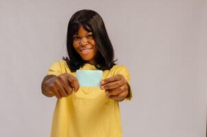 Woman holds a blank business card out in front of her smiling face. photo