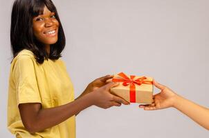 Valentine's day concept. A giftbox with red ribbon in hands. Loving couple give each other presents on 14 February. Romantic Boyfriend and girlfriend celebrating lover's day photo