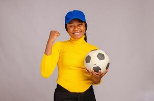 hermosa africano dama sonriente como ella sostener fútbol americano foto