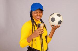 Young beautiful lady making sport bets online using mobile application. photo