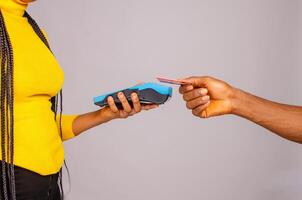 Cropped image of customer paying with credit card holding payment terminal photo