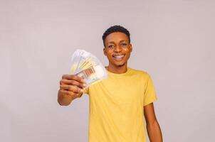 excited young african boy pointing out his cash and smiling photo