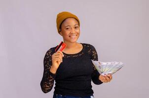 Happy young woman holding money and credit card. photo