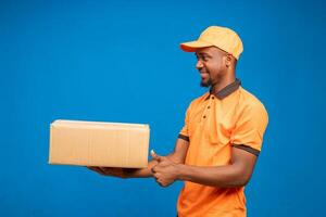 handsome african man smiling as he points the delivery package photo
